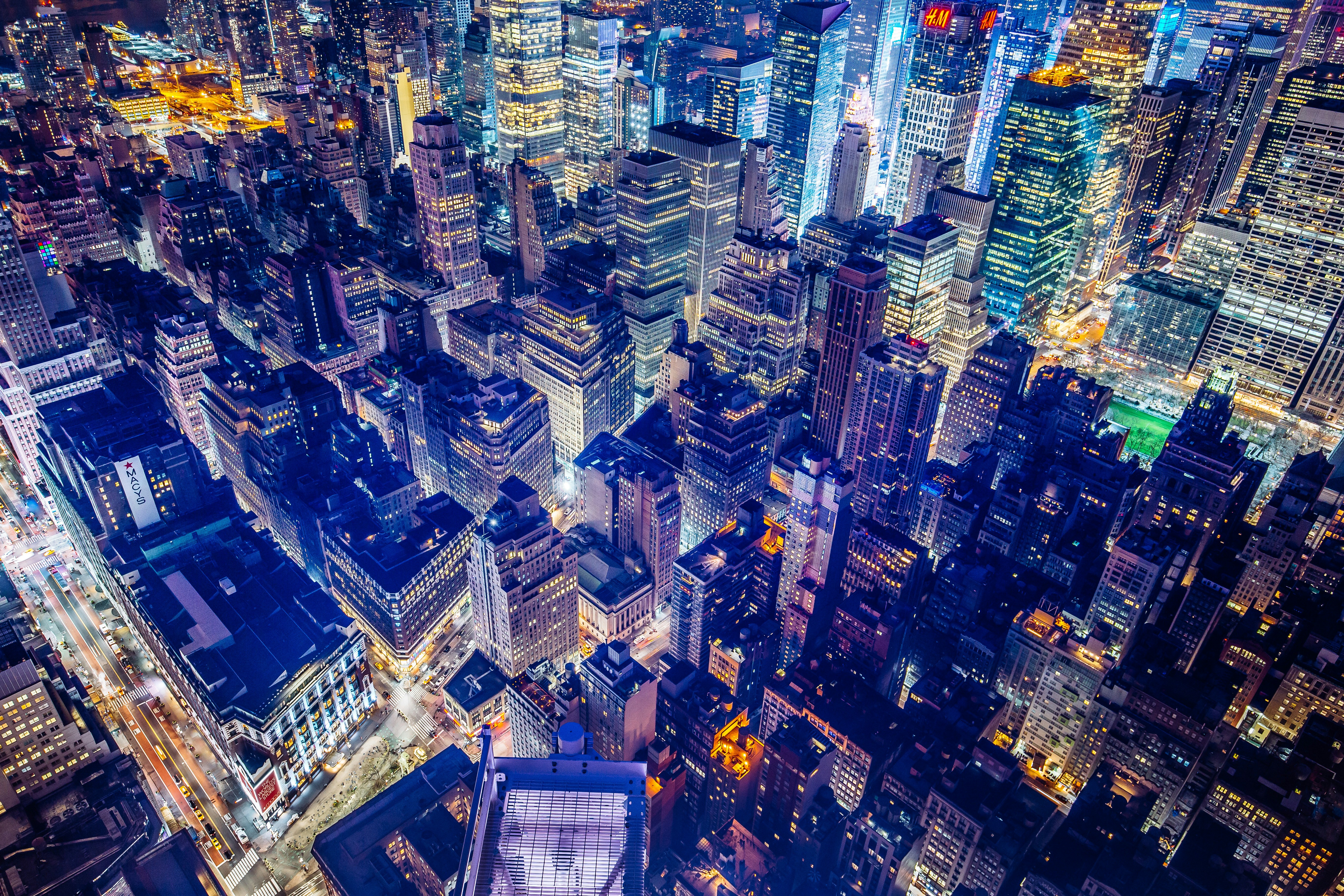 Aerial view of a city skyline at night, illuminated by city lights.