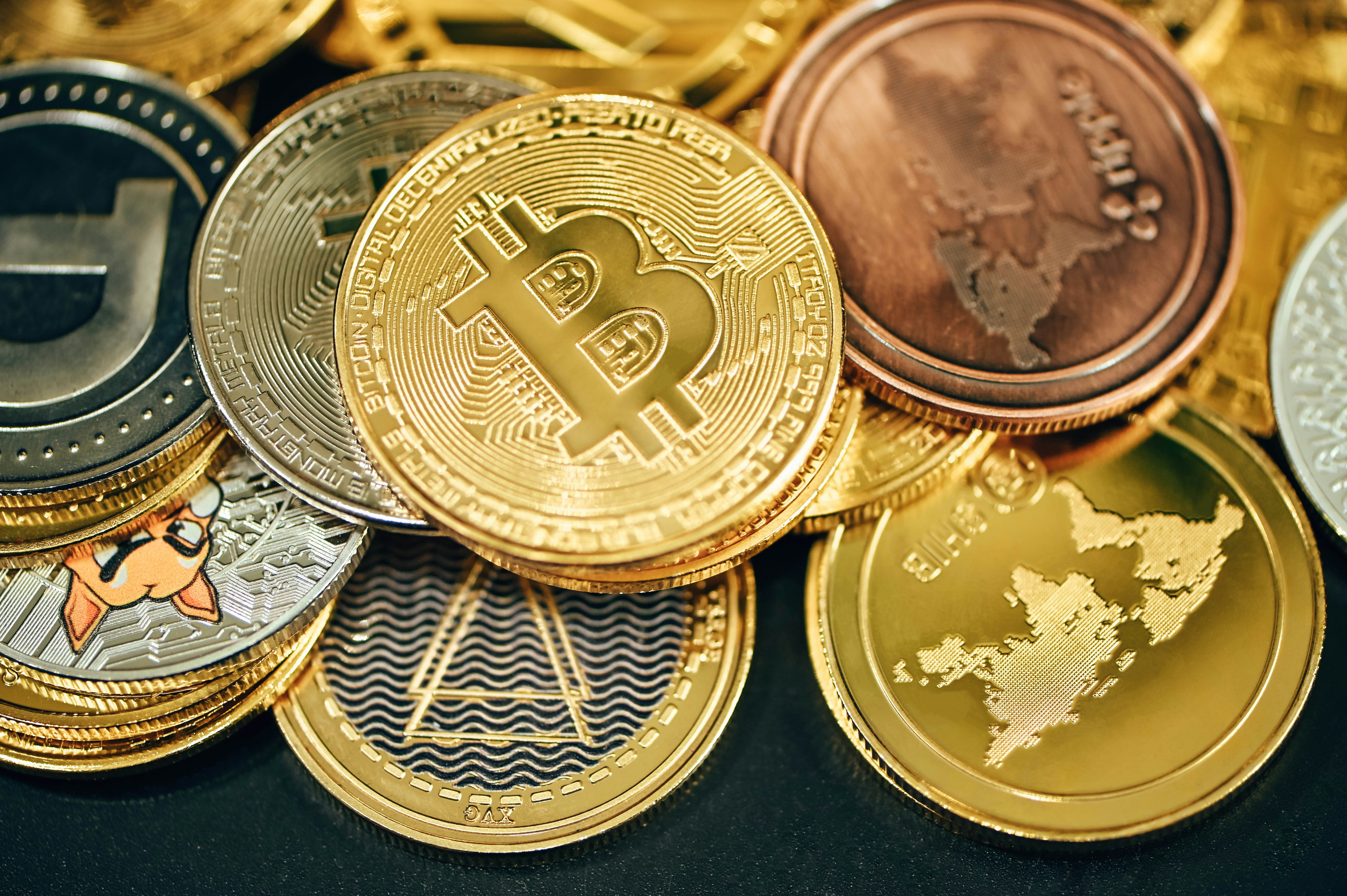 A close-up view of various cryptocurrency coins including Bitcoin and others.